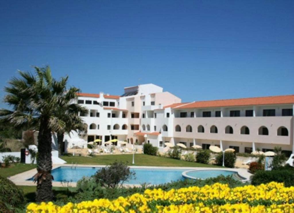 a resort with a swimming pool and a building at Don Tenorio Aparthotel in Sagres