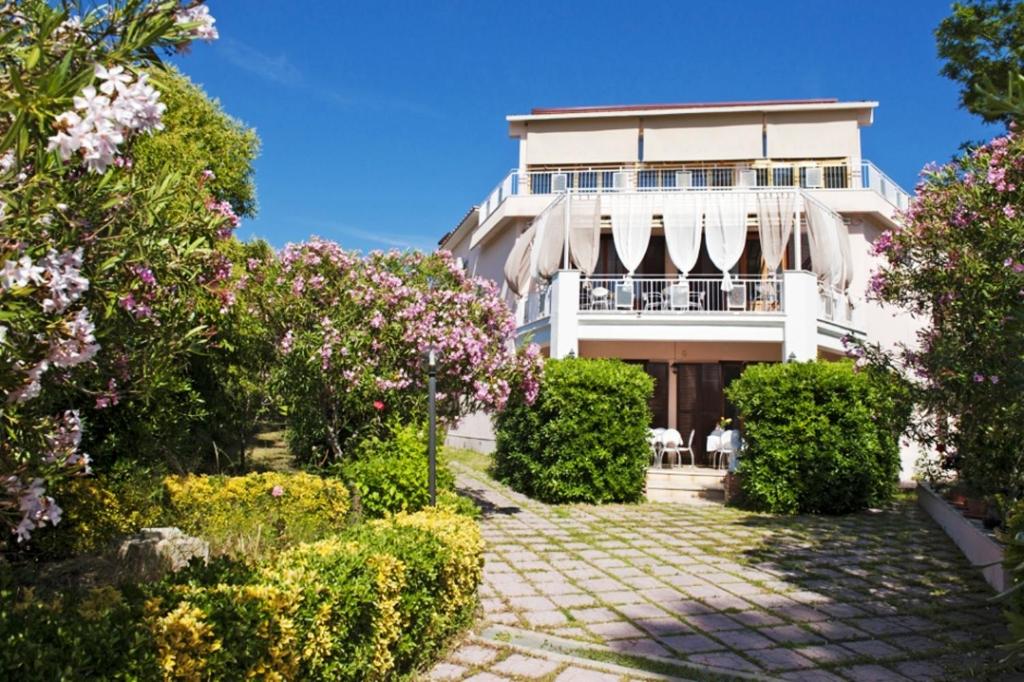 a large white building with flowers in front of it at I Tre Leoni Affittacamere in Civitavecchia