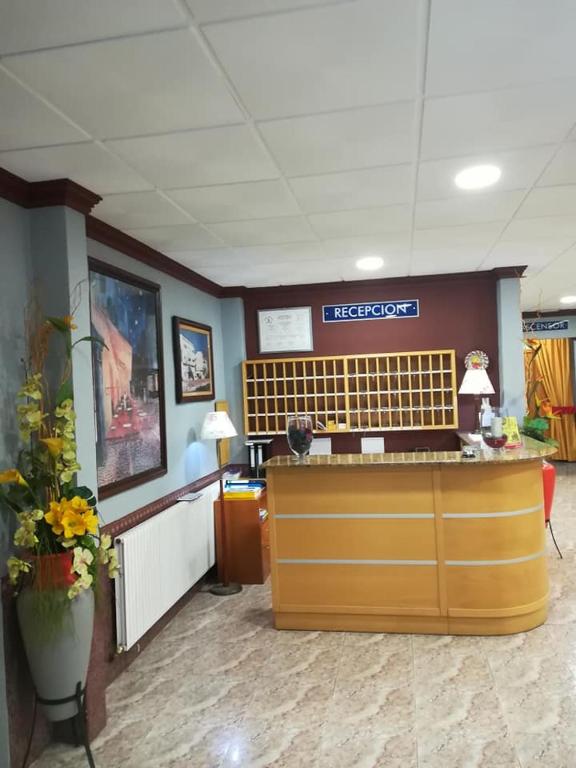 a waiting room with a reception desk and flowers at Hotel La Bolera in Vinarós