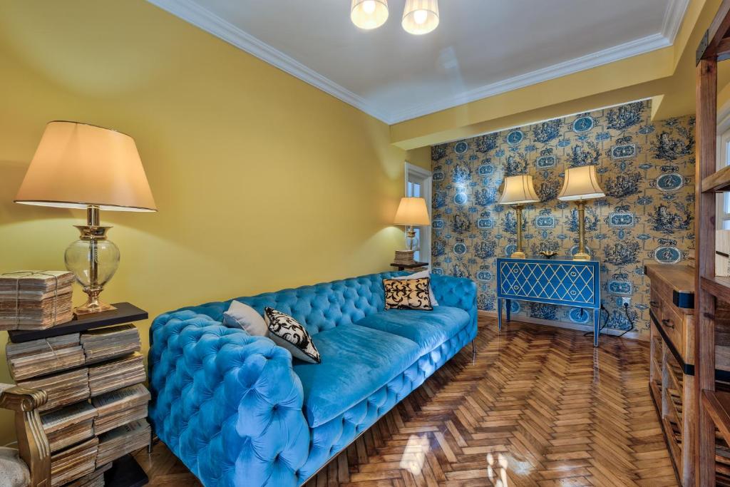 - un canapé bleu dans un salon aux murs jaunes dans l'établissement Le Park, à Bucarest
