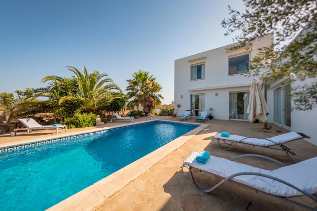 a villa with a swimming pool and a house at Villa Can Massaueta in Sant Jordi
