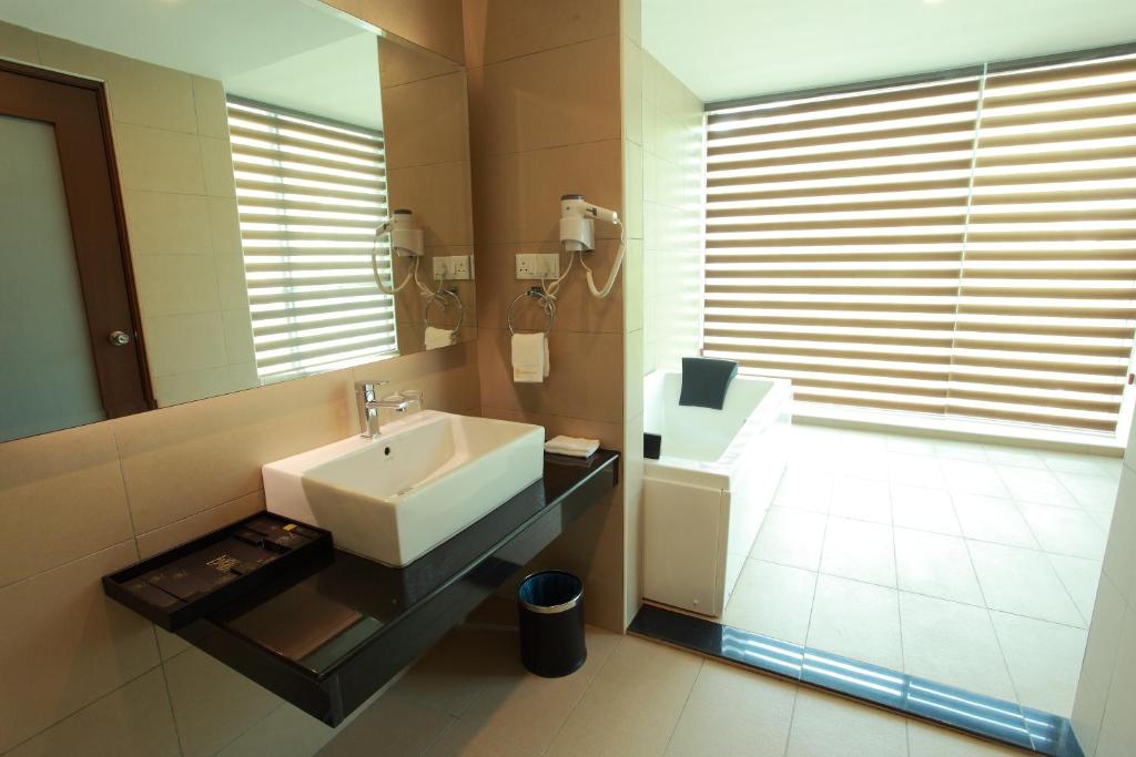 a bathroom with a sink and a mirror at Symphony Suites Hotel in Ipoh