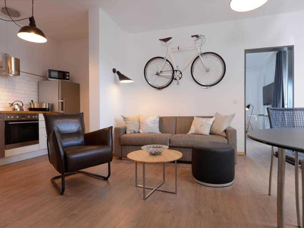 a living room with a couch and a bike hanging on the wall at Ohlerich Speicher App_ 07 in Wismar
