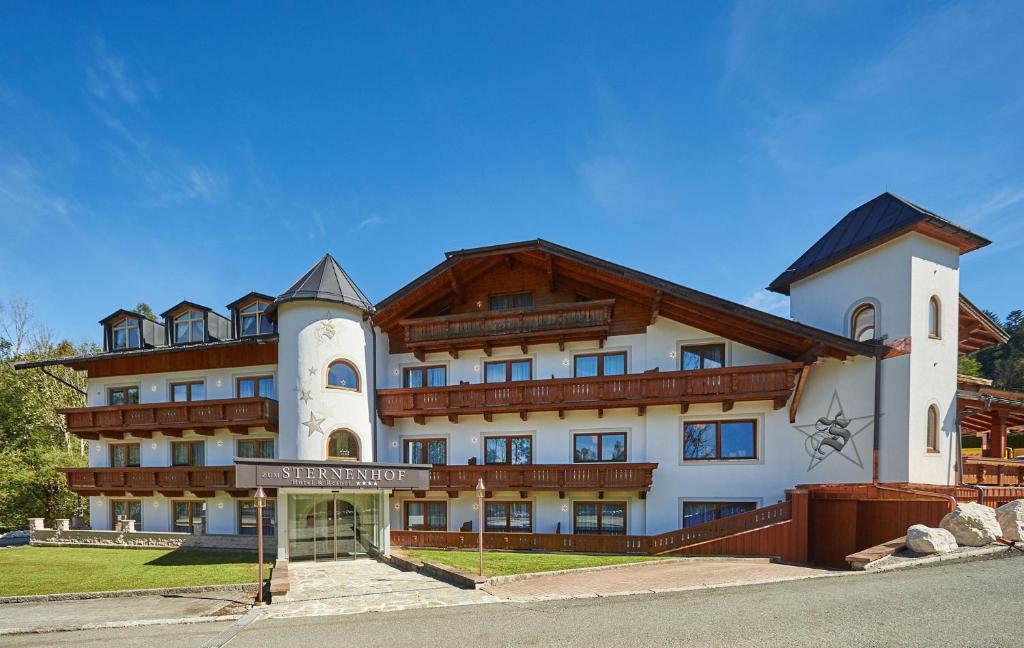 a large building with a sign in front of it at Hotel ZUM STERNENHOF in Kössen