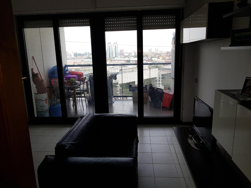 un soggiorno con divano di fronte a una finestra di Bisceglie Aparthotel a Milano