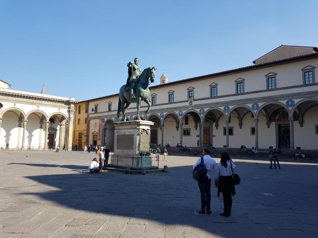 a group of people standing in front of a building with a statue at B&B i Rinascimenti in Florence