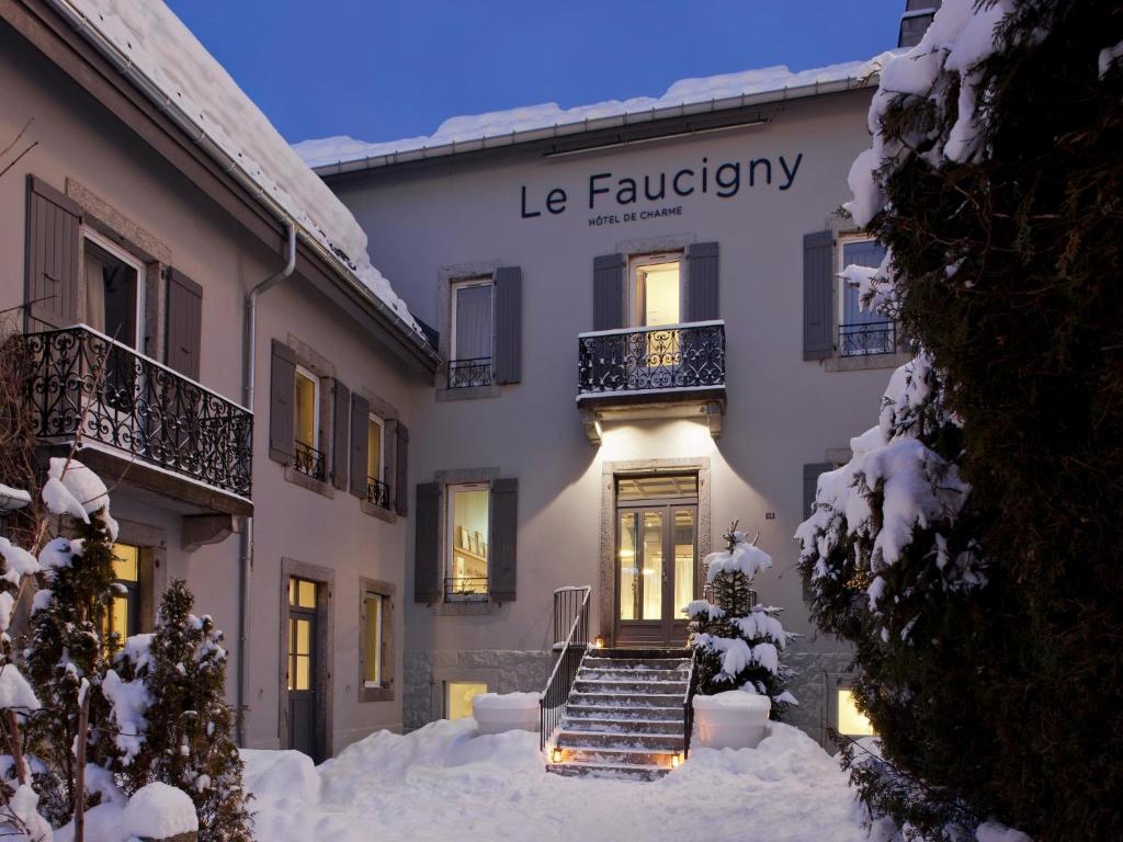 un bâtiment avec de la neige devant lui dans l'établissement Le Faucigny - Hotel de Charme, à Chamonix-Mont-Blanc