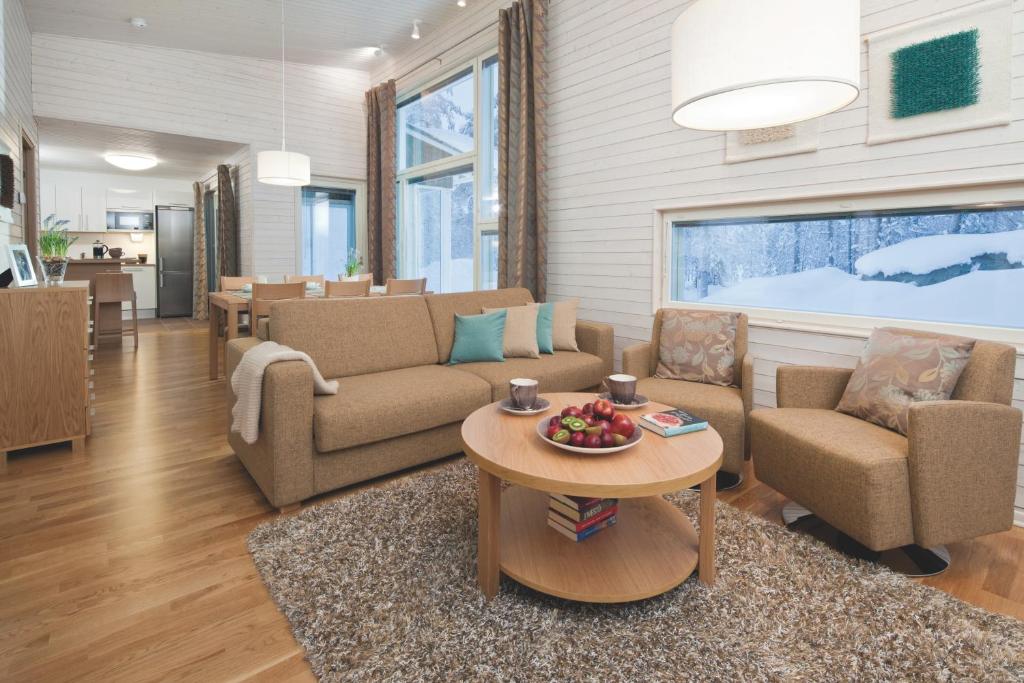 una sala de estar con un sofá y una mesa en Holiday Club Kuusamon Tropiikki Superior Apartments, en Kuusamo