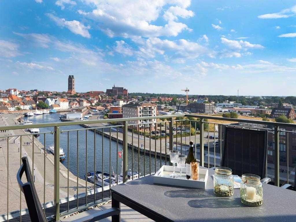 uma mesa numa varanda com vista para a água em Ohlerich Speicher App_ 44 em Wismar