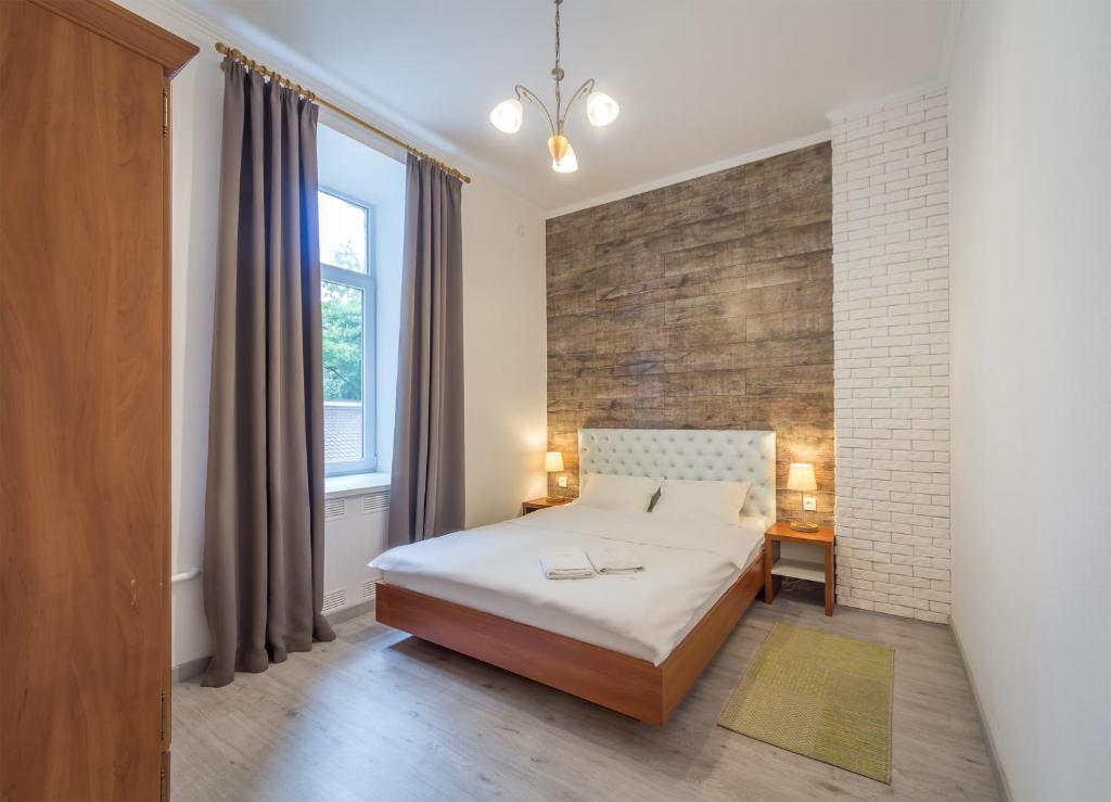 a bedroom with a bed and a brick wall at DayFlat Apartments Olimpiyska Area in Kyiv