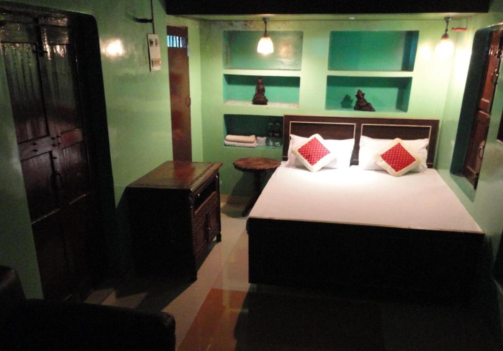 um quarto com uma cama com paredes vermelhas e verdes em Shiva Guest House em Varanasi