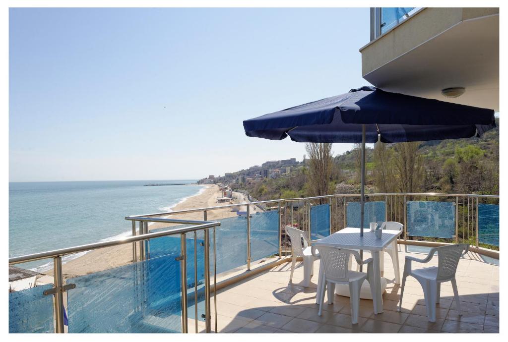 - un balcon avec une table et des chaises et la plage dans l'établissement Kabakum Apartments, aux Sables d'or