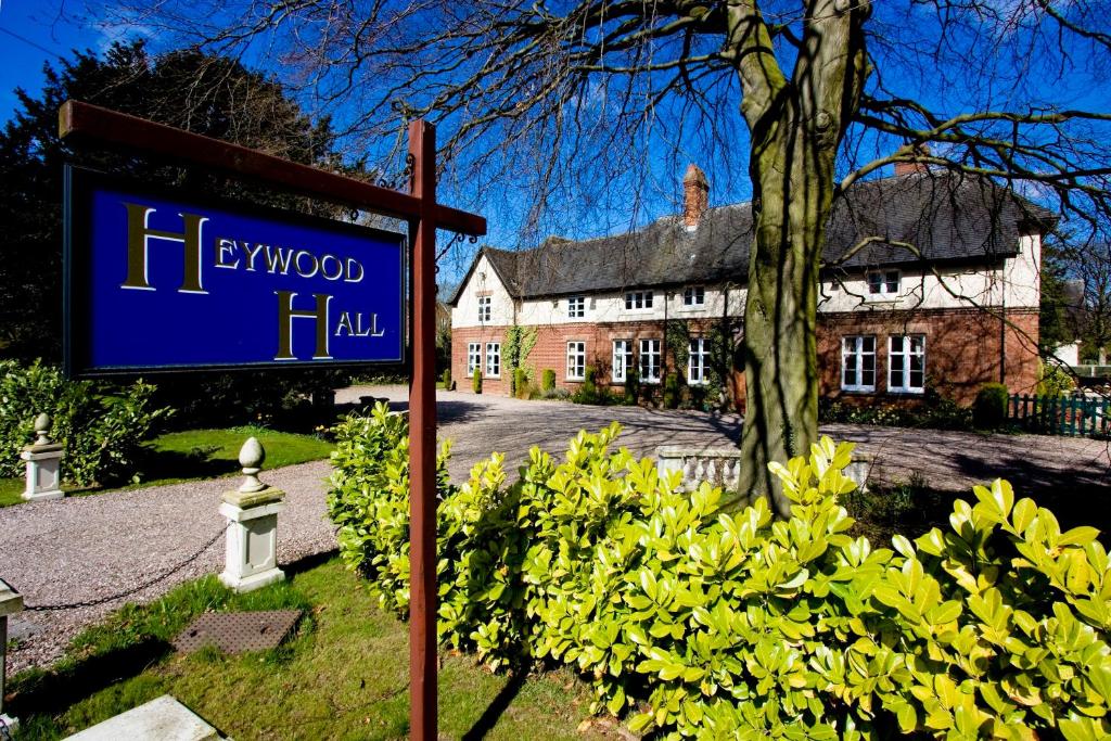 un letrero para un hotel frente a una casa en Heywood Hall, en Denstone