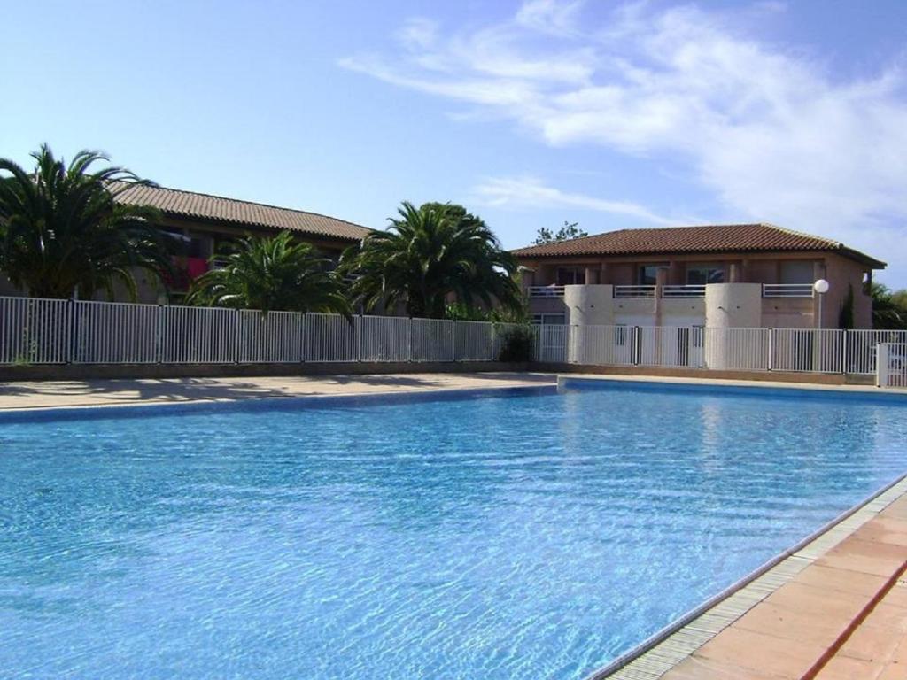 a large swimming pool in front of a house at Gîte classé 3 étoiles dans résidence standing avec - Piscine Clim Parking Wifi Prêt Vélos - Ménage et linge non inclus in Saint-Cyprien