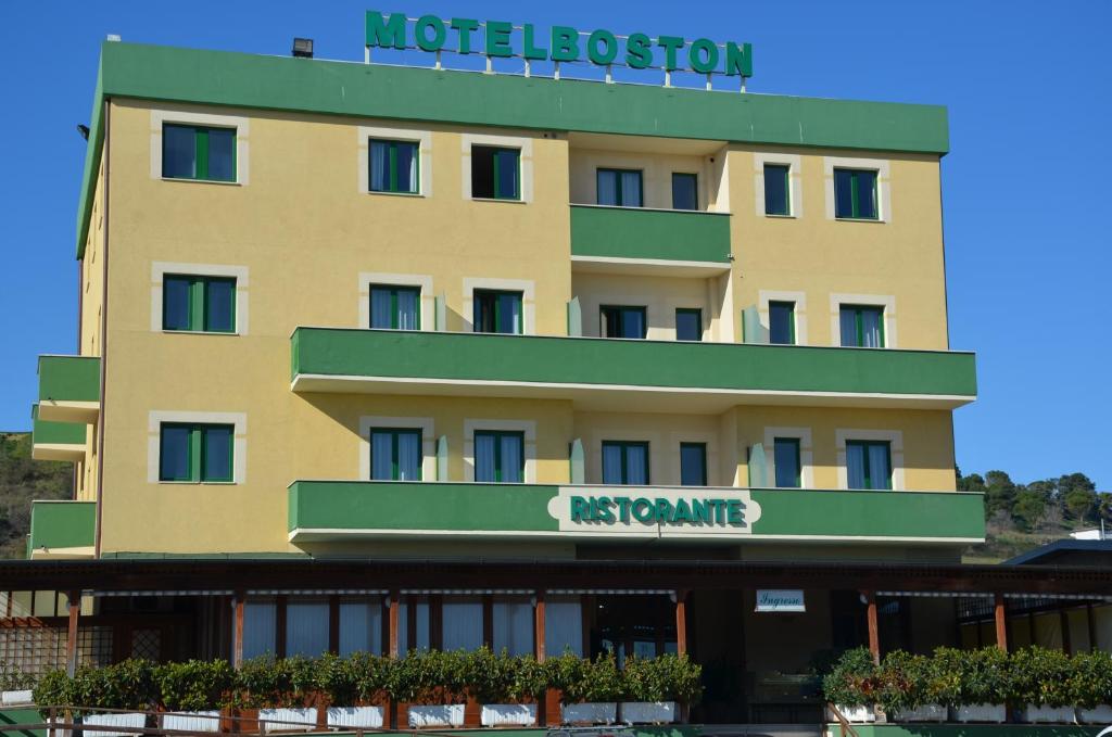 a large yellow building with a sign for a hotel at Motel Boston in Silvi Marina