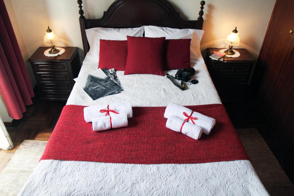 a bed with red pillows and bows on it at Hotel GORDON in Funchal