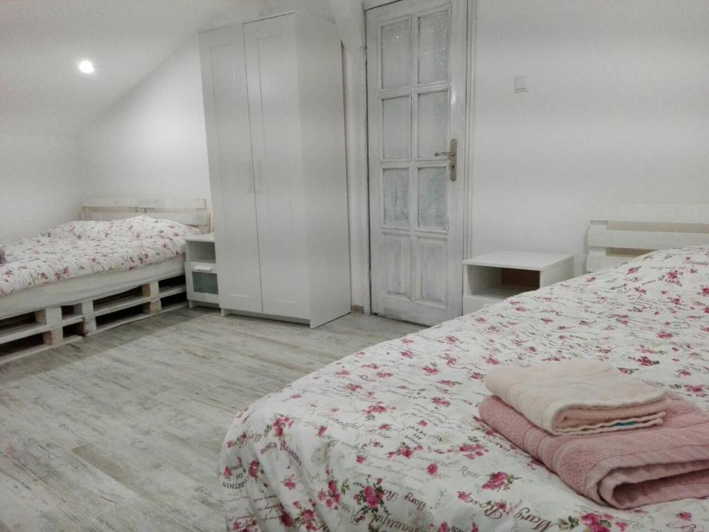 a white bedroom with two beds and a window at INFINITY Blue 1 in Burgas