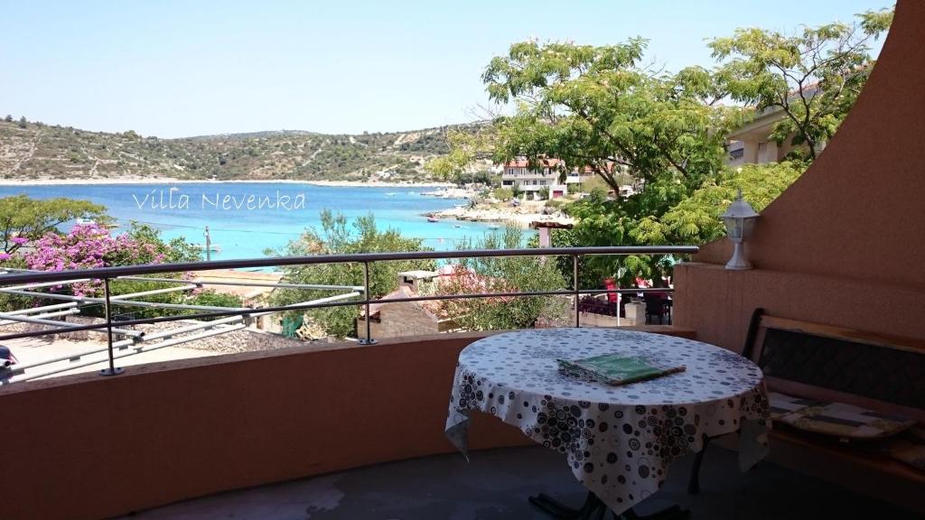 a balcony with a table and a view of the water at Apartment Rogoznica/Sibenik Riviera 7186 in Zaglavice