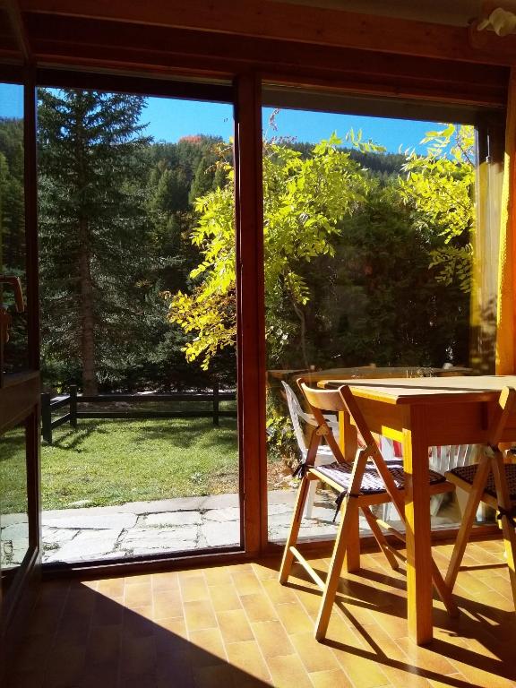 une pièce avec une table, des chaises et une fenêtre dans l'établissement studio isabelle, à Saint-Chaffrey
