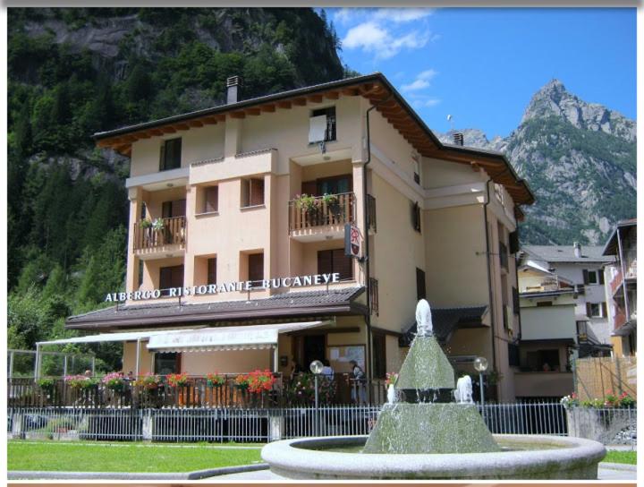 a building with a fountain in front of a building at Hotel ristorante Bucaneve in Val Masino