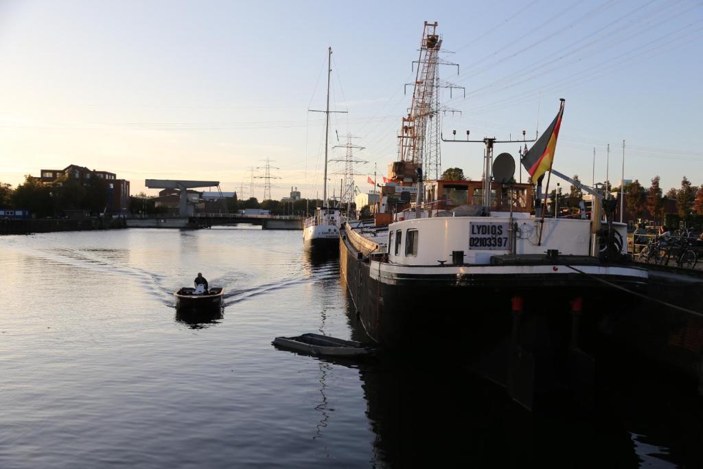 two boats are docked in the water next to a pier at Schiffshotel "Schlafen im Hafen" in Hamburg