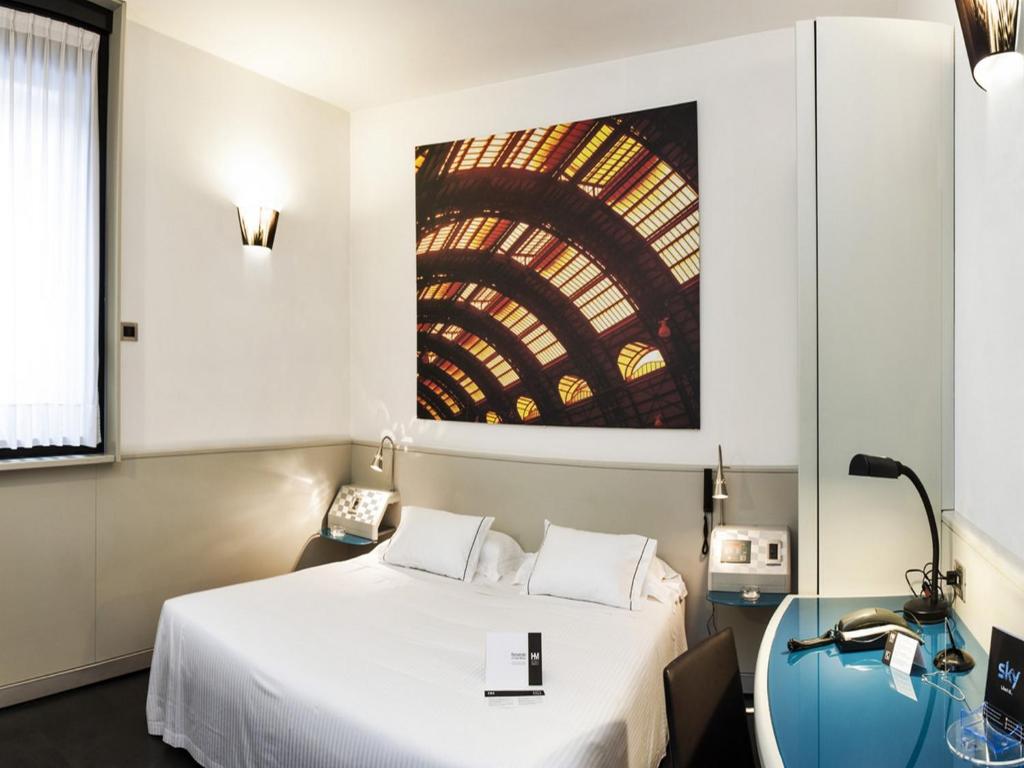 una camera con un letto e un dipinto sul muro di Hotel Milano a Padova