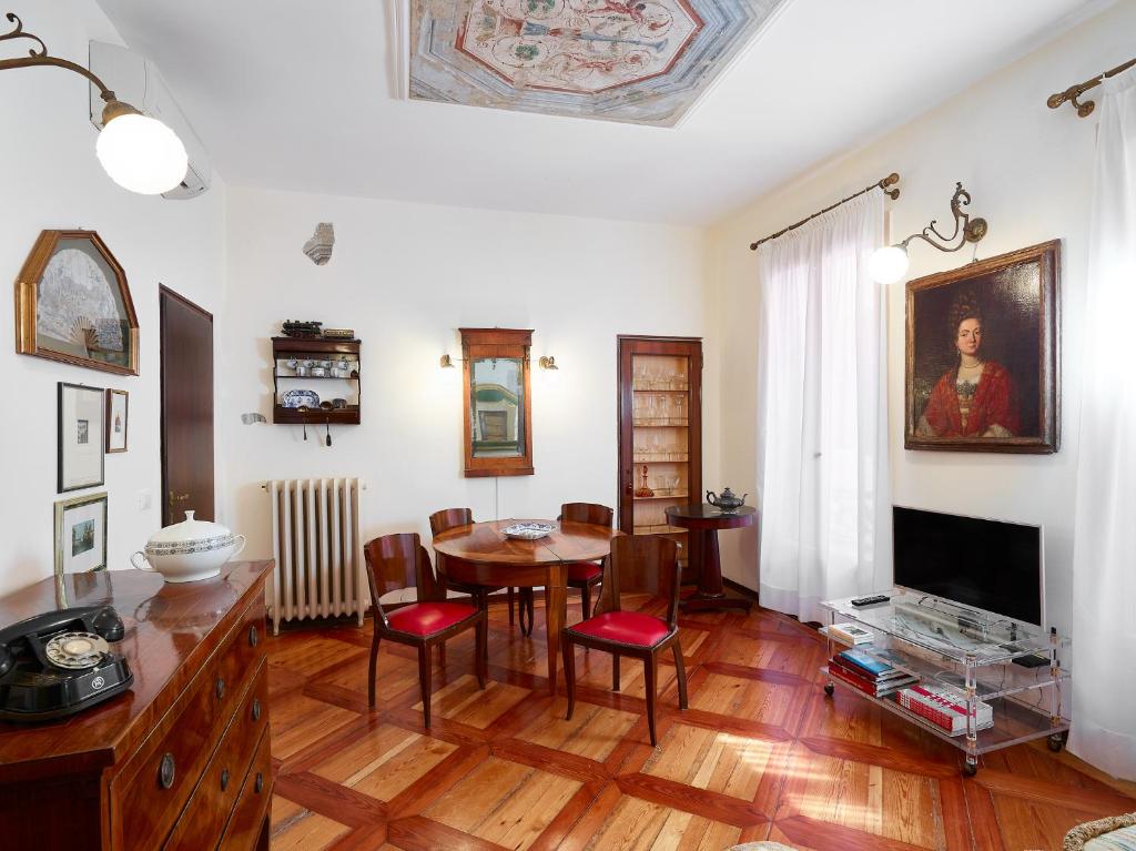 - un salon avec une table et une salle à manger dans l'établissement Palazzo Morosini Brandolin Dimora Romantica, à Venise