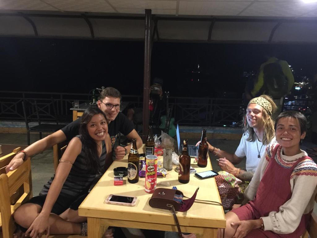 un gruppo di persone seduti a un tavolo con bevande di Lake Vision Guesthouse a Pokhara