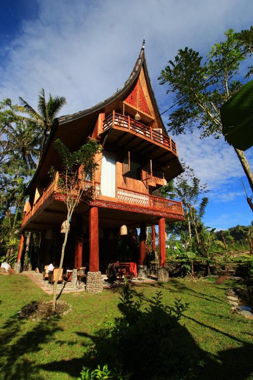 a large wooden house with a roof at Padi Ecolodge in Bukittinggi