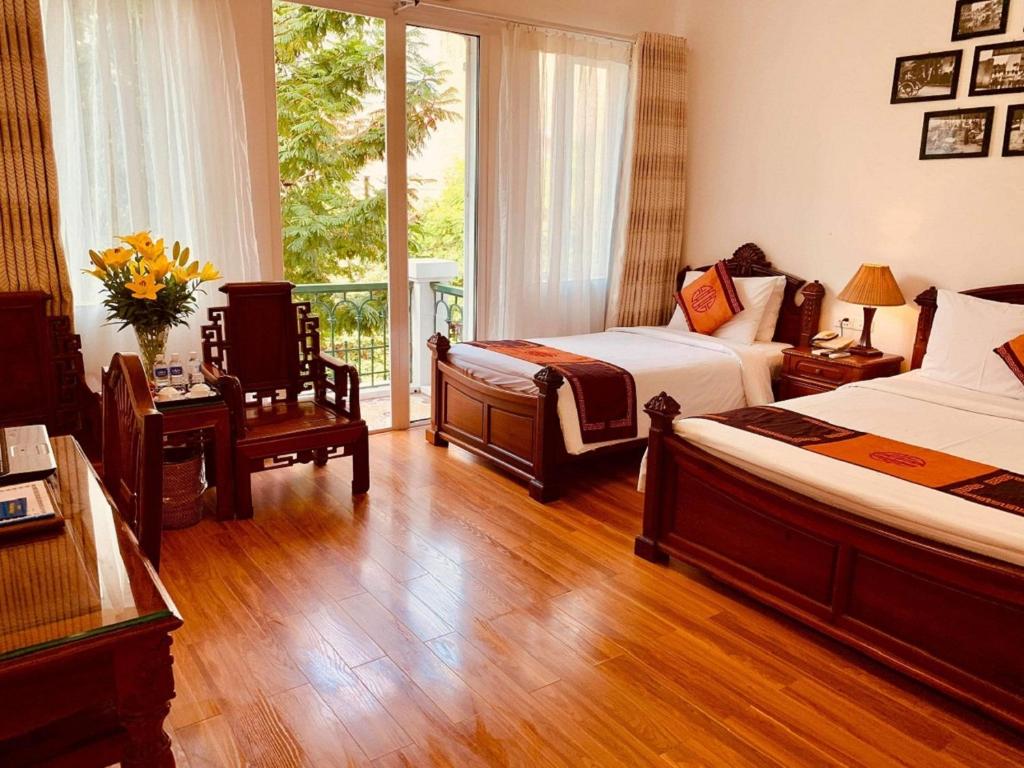 ein Hotelzimmer mit 2 Betten und einem Balkon in der Unterkunft Phoenix Palace Hotel Hanoi in Hanoi