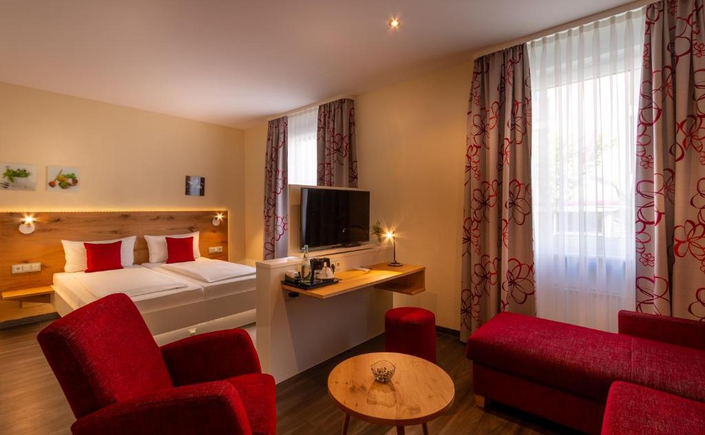 Habitación de hotel con cama y TV en Hotel Zum Rosengarten, en Darmstadt