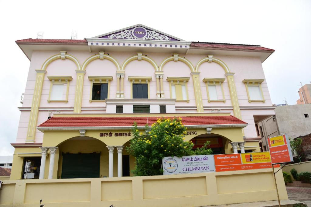 a large white building with a red roof at Hotel Chembiyan in Pudukkottai