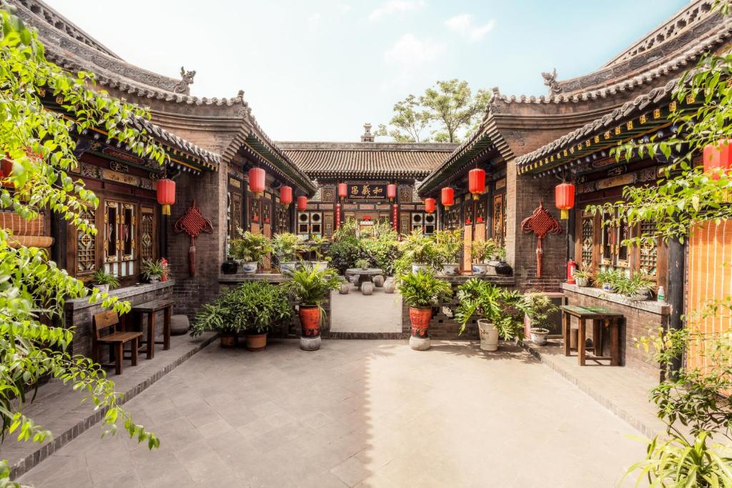 a courtyard of a building with potted plants at Pingyao Harmony Hotel in Pingyao