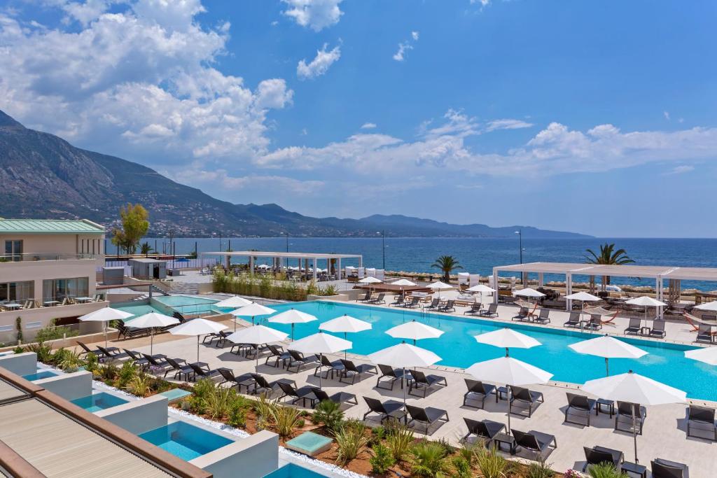 vista sulla piscina in un resort con sedie e ombrelloni di Horizon Blu Boutique Hotel a Kalamáta