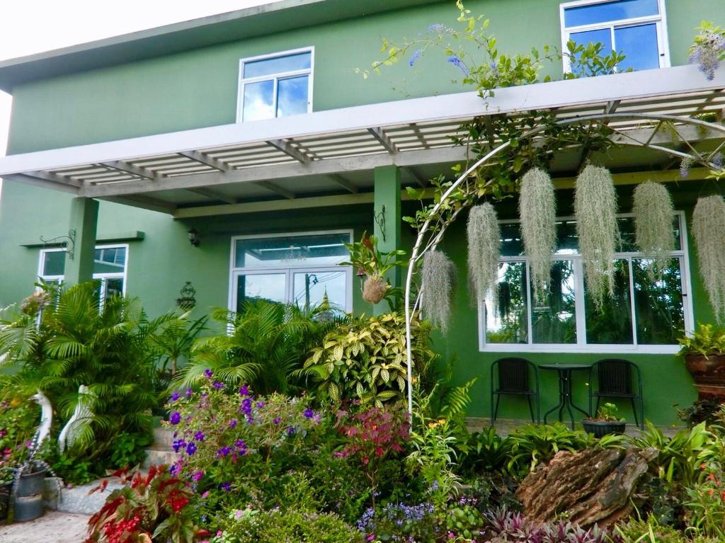 a green house with flowers in front of it at Green View 104 Khao Kho in Khao Kho