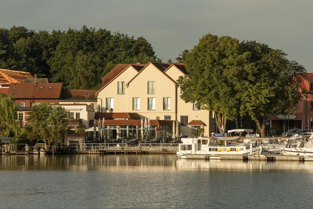 eine Gruppe von Booten, die an einem Yachthafen auf dem Wasser angedockt sind in der Unterkunft Hotel Müritzterrasse in Röbel