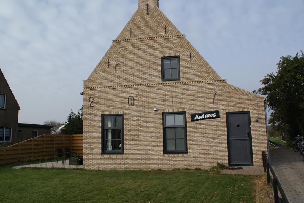 un grand bâtiment en briques avec une pyramide au sommet dans l'établissement Antares-Ameland, à Hollum