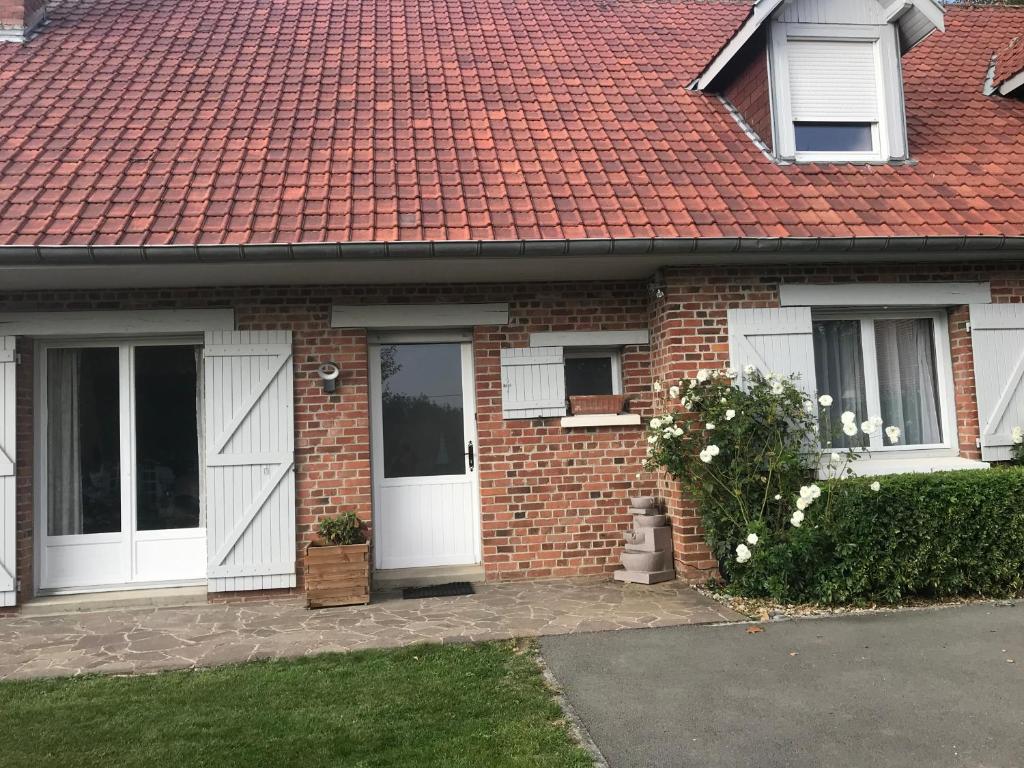 a brick house with white doors and a red roof at Gite du Crinchon in Rivière