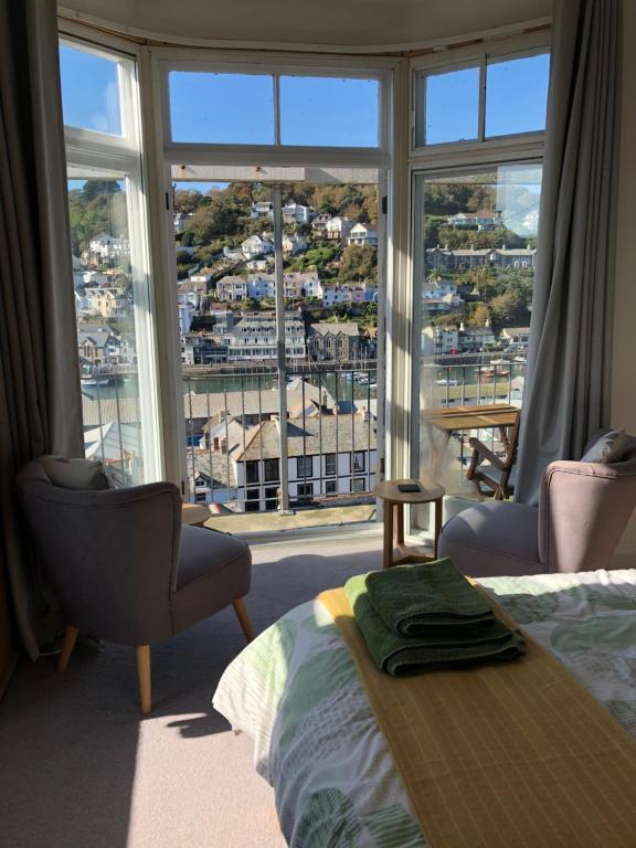 a bedroom with a bed and a large window at Penwyn Bed and Breakfast in Looe