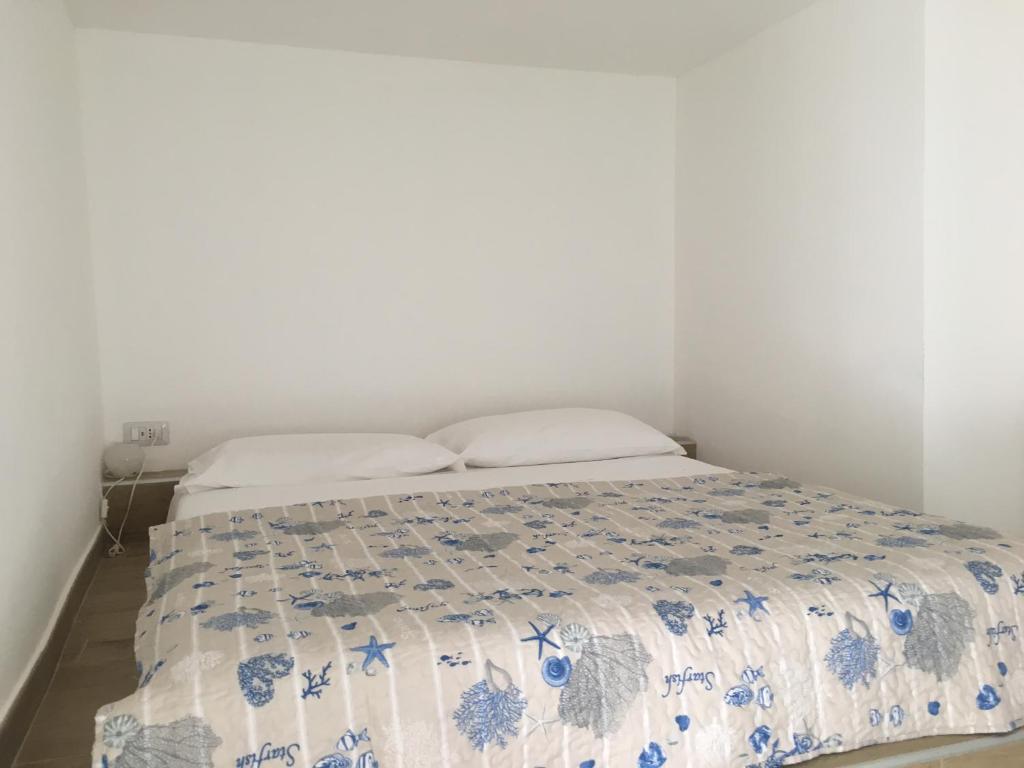 sypialnia z łóżkiem z niebiesko-białą kołdrą w obiekcie JULES PLACE w mieście Lecco