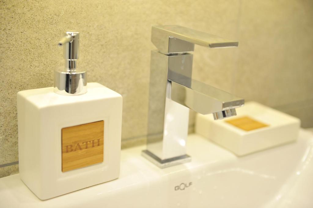 a white soap dispenser sitting on top of a sink at Milmari Resort Premier 47 in Kopaonik