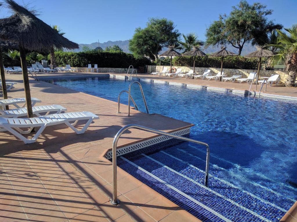 una gran piscina con sillas y sombrillas en Los Gallardos Leisure en Los Gallardos