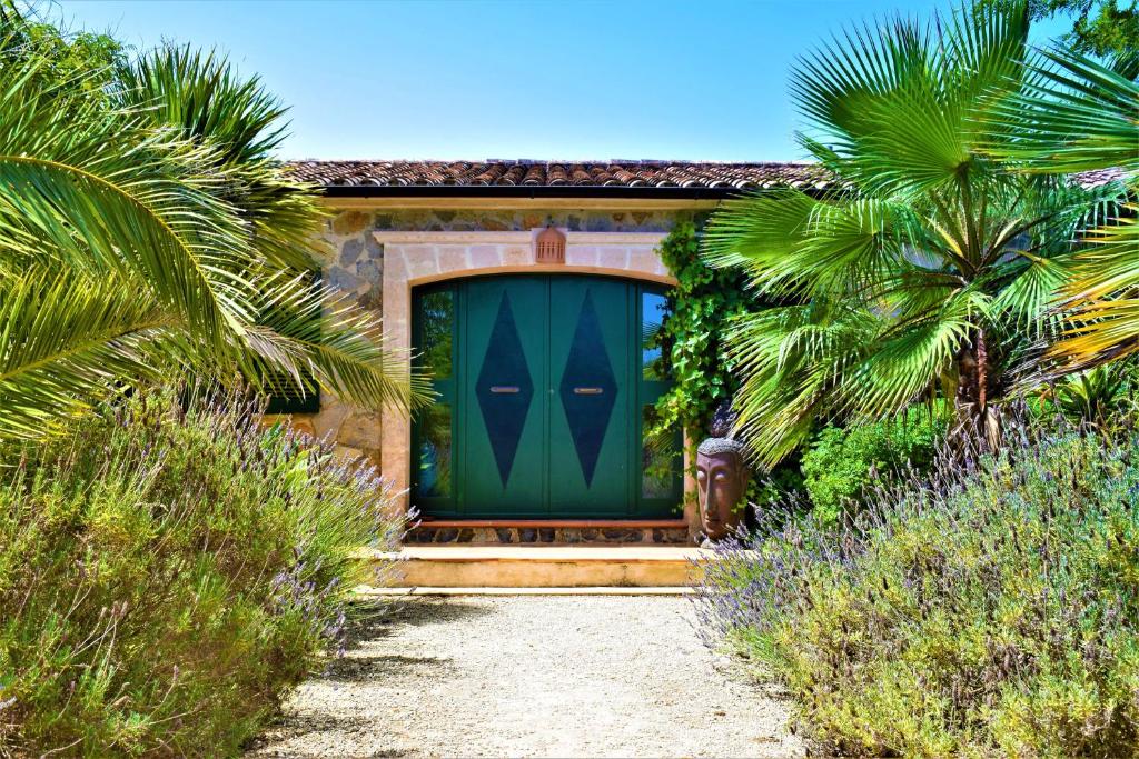 una porta verde su una casa con palme di Finca Bona Sort a Capdepera