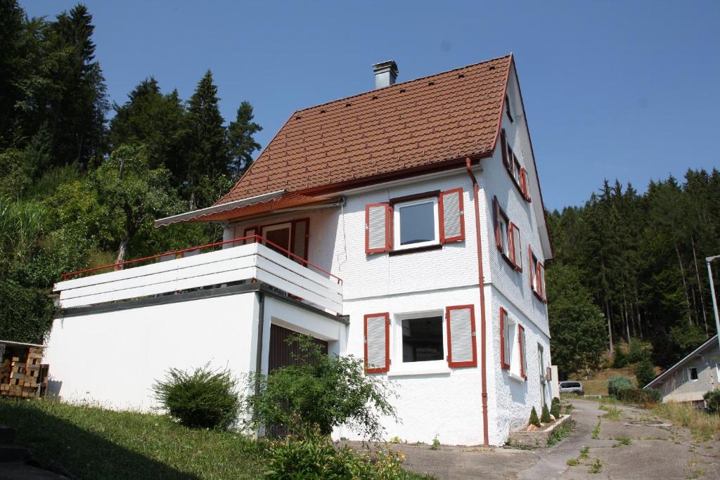 a small white house with a brown roof at BlackforestBike&HikeHouse in Baiersbronn