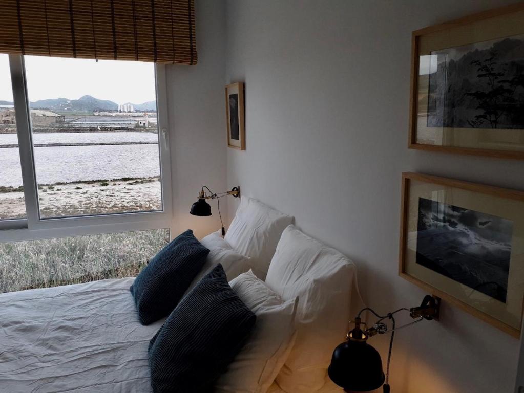 a bedroom with a bed with pillows and a window at Cabo Palos Apt Salinas Marchamalo*Playa Amoladeras in Cabo de Palos