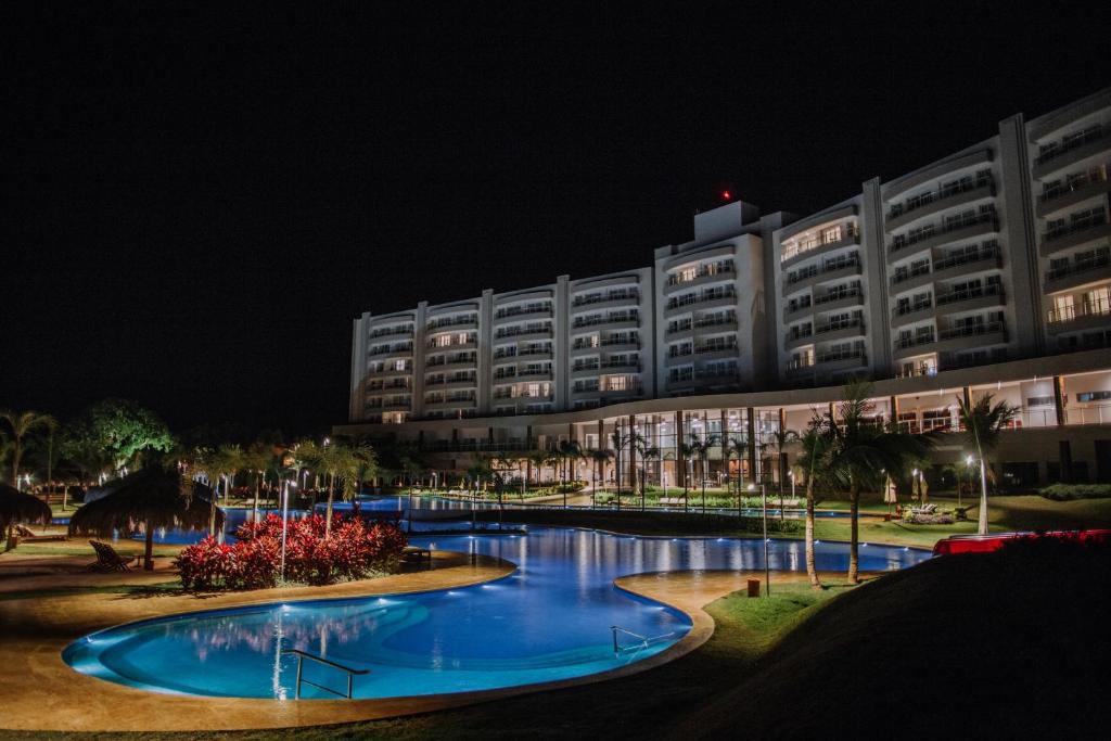 a large building with a large swimming pool at night at Tayayá Aqua Resort in Ribeirão Claro