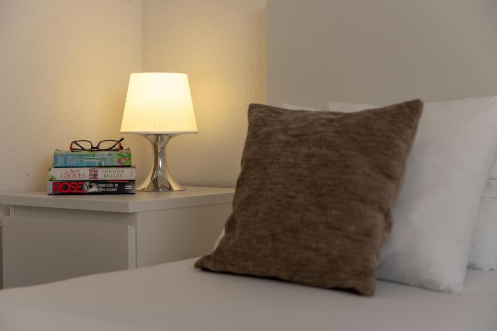 una almohada sentada en una cama junto a una lámpara en Villa Kuzmanić, en Trogir