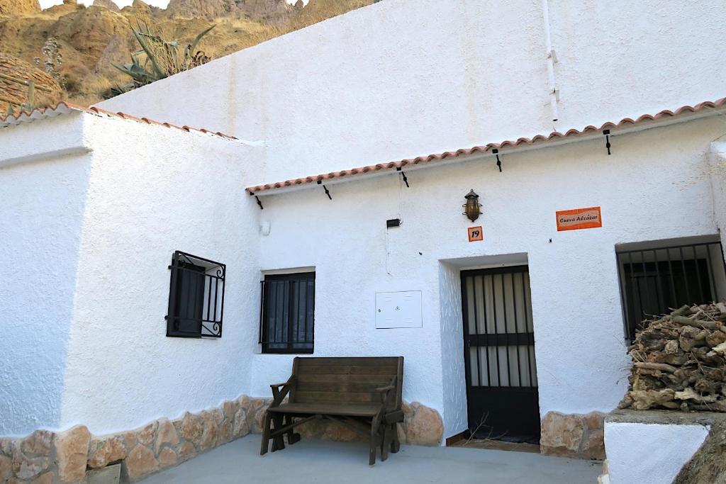 Cueva Alcázar في Gorafe: مبنى أبيض أمامه مقعد