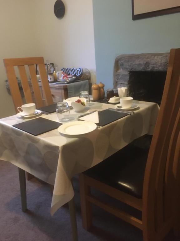 a table with a white table cloth on top of it at Garth Engan Private Self Contained B&B with Garden Area in Llanbedr