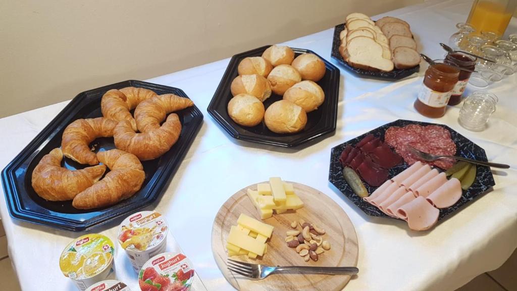 a table topped with different types of bread and pastries at Hotel Restaurant Edelweiss in Mühlen